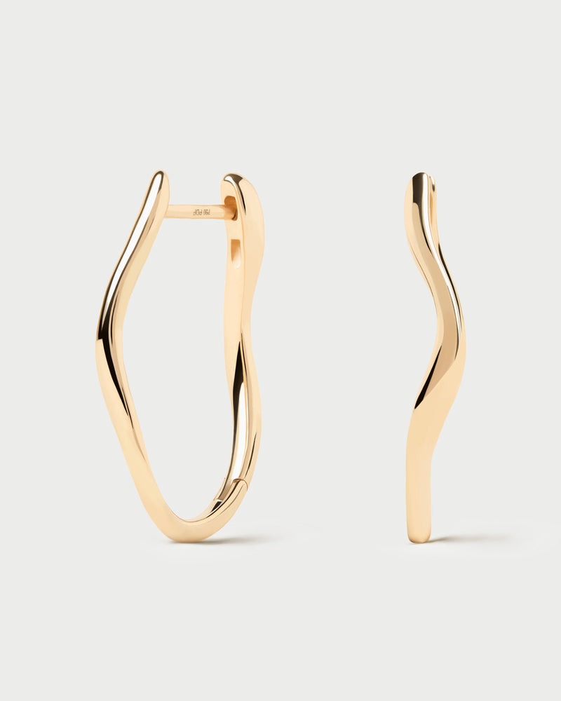 Modern large oval hoops in 18K yellow gold featuring fluid lines
