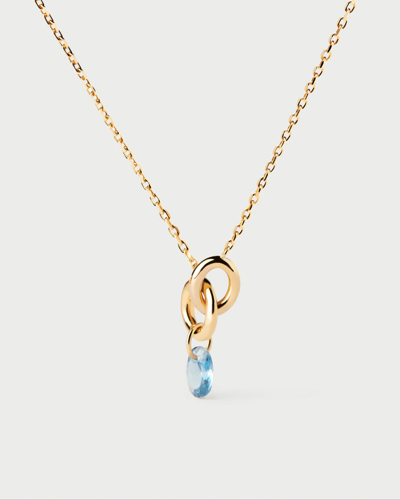 Gold-plated necklace featuring two interlinked rings with a blue zirconia drop pendant