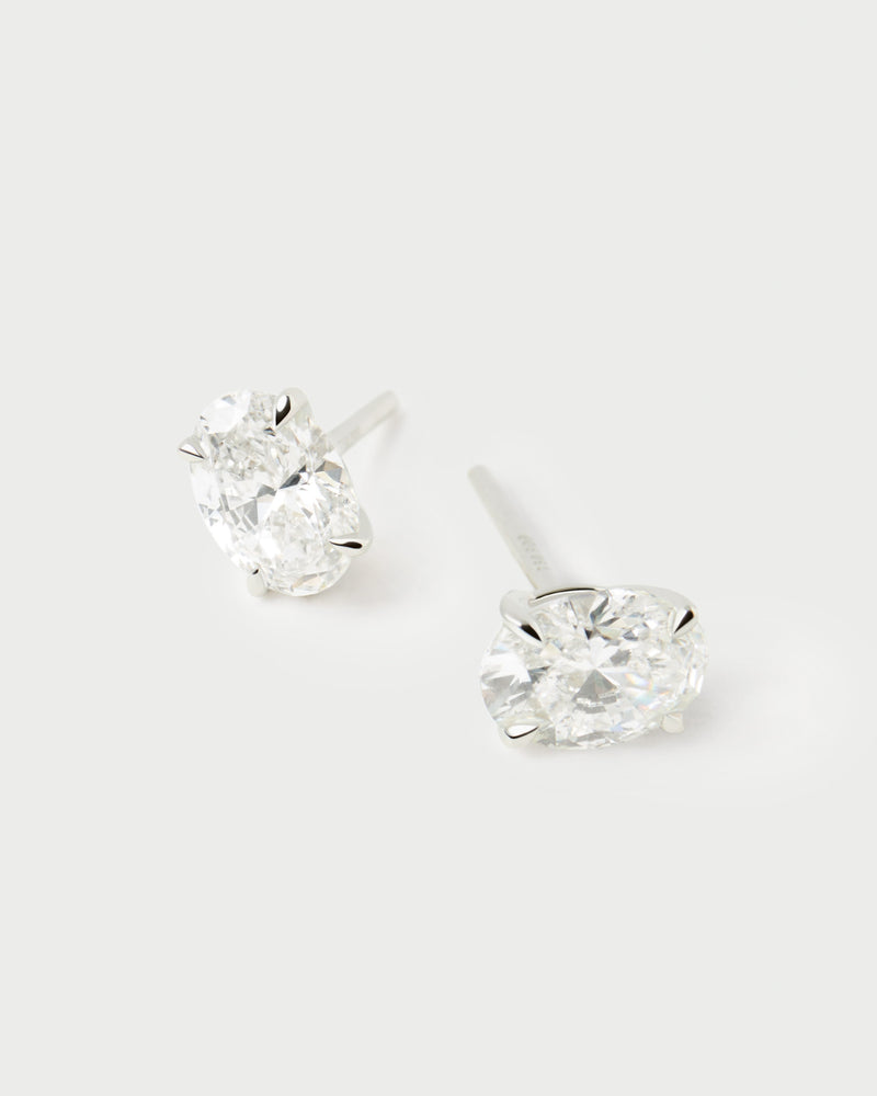 White gold diamond stud earrings with an oval half-bezel lab-grown diamond