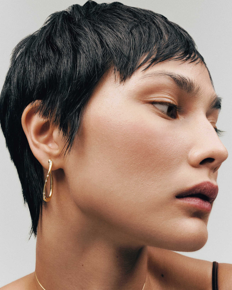 Large wavy hoop earrings adorned with sparkling zirconia accents